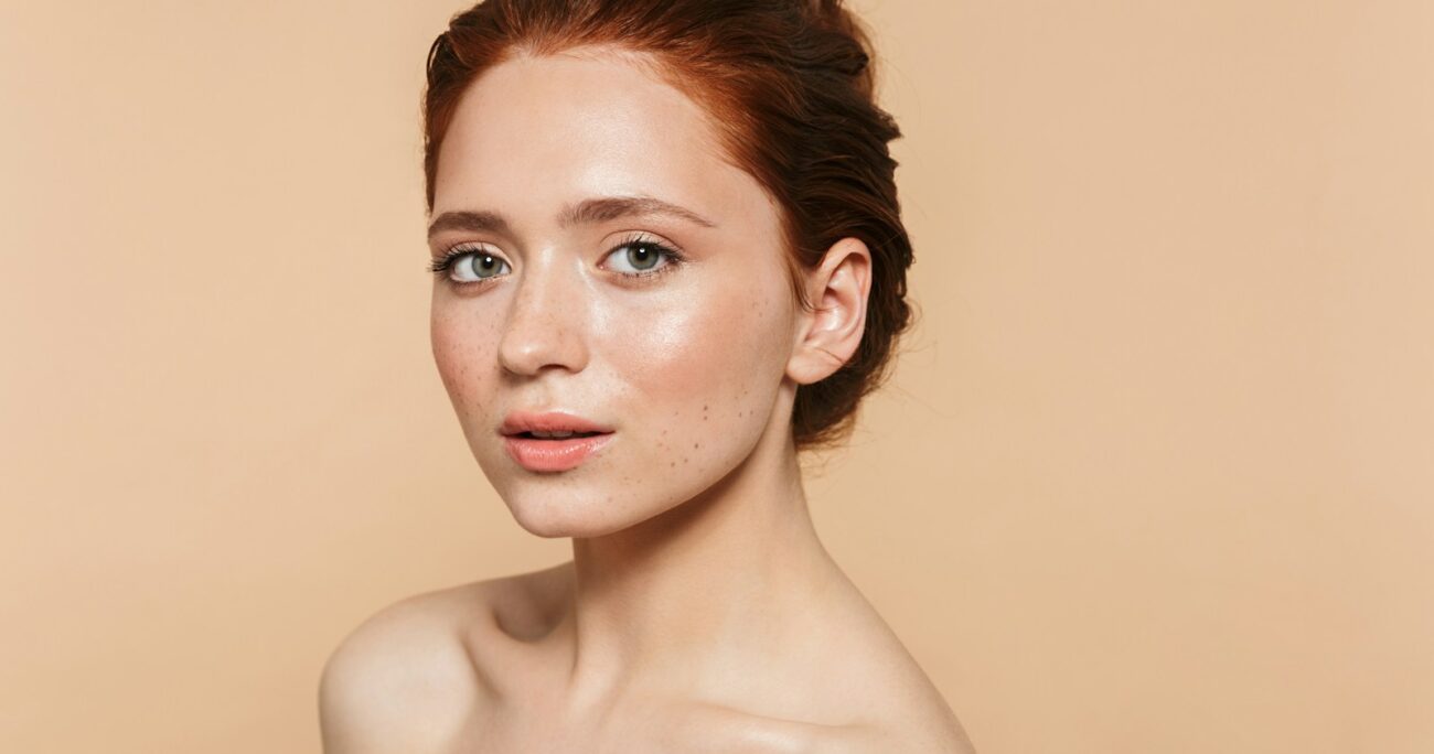 A woman with red hair is posing for a picture