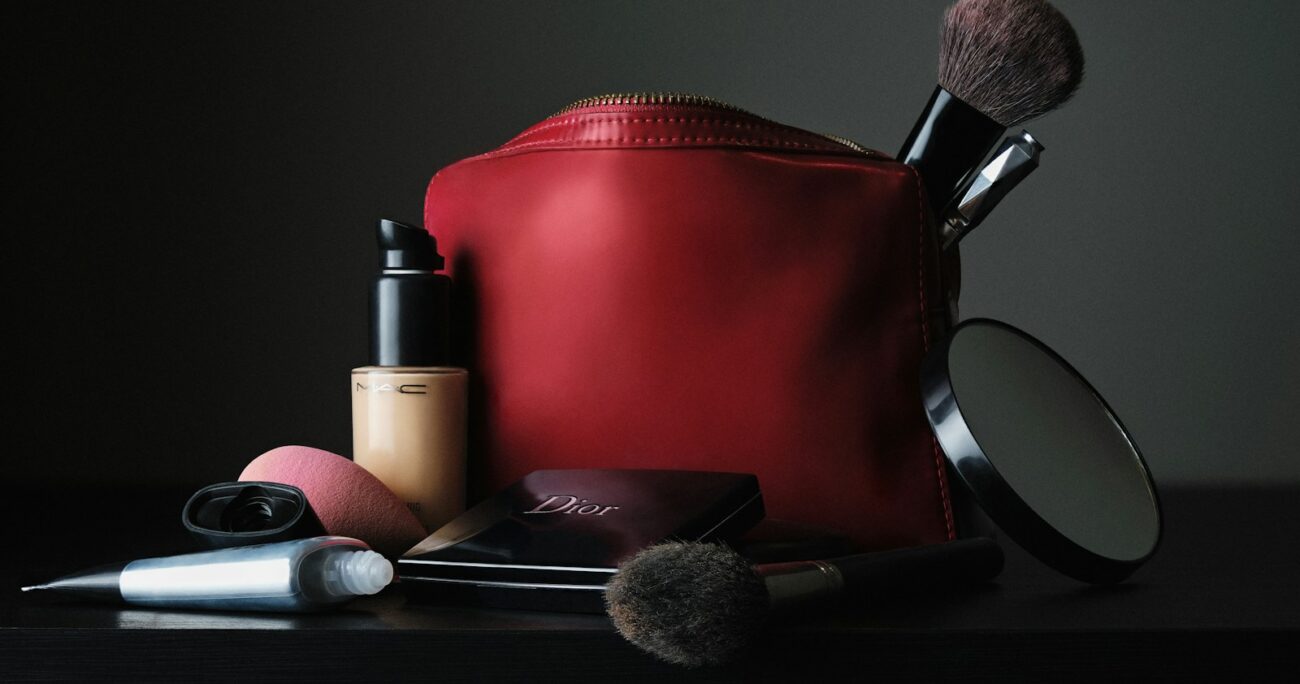 red leather bag beside black makeup brush